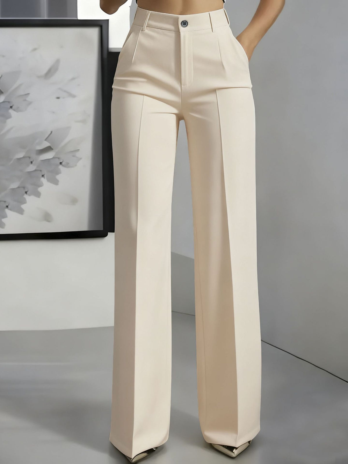 Frontansicht an Model: weit geschnittene Bundfaltenhose in Cremebeige mit Knopfverschluss und Bügelfalte, eine Hand in der 5