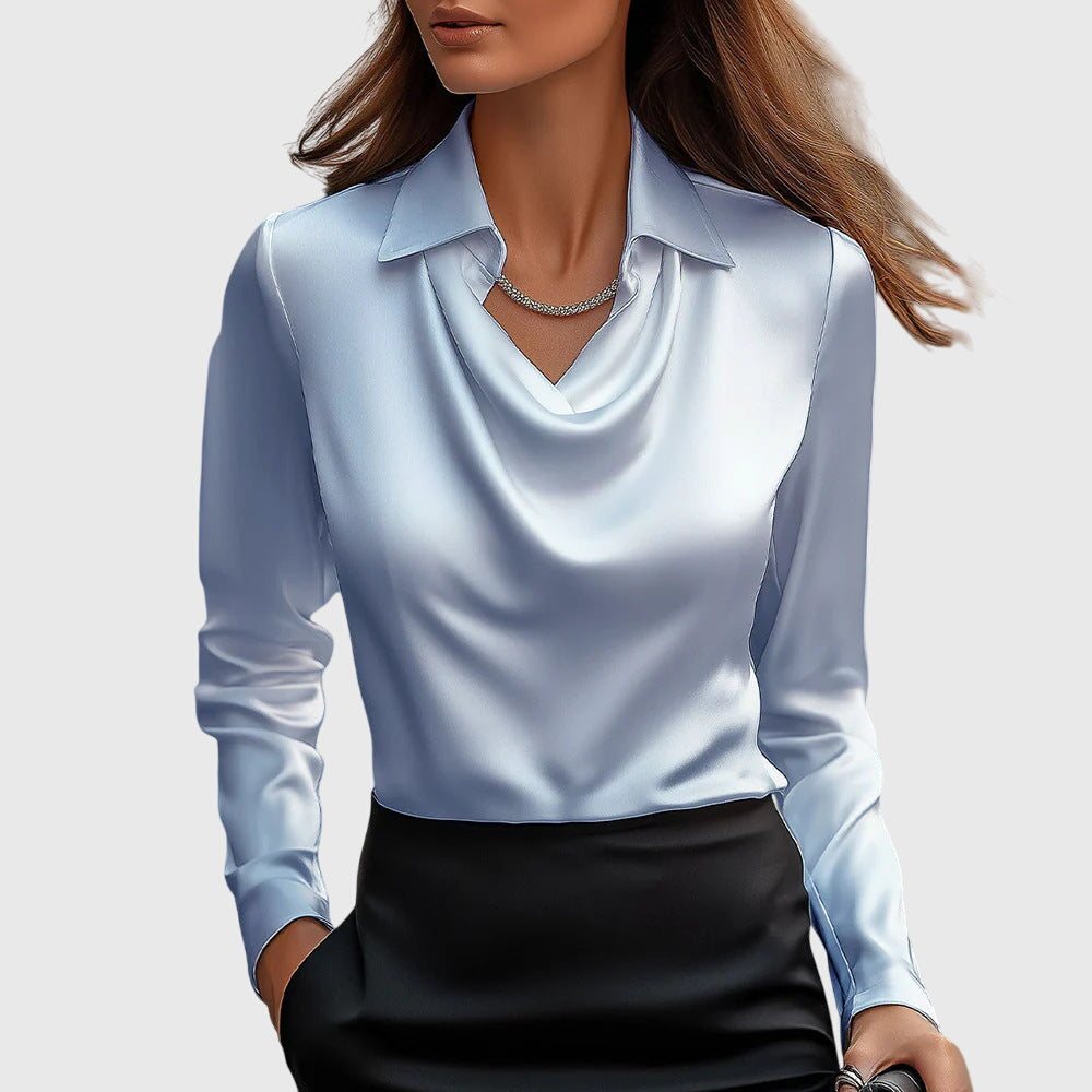 Damen Satin-Bluse in Hellblau mit Kragen und drapiertem Wasserfallausschnitt, kombiniert mit schwarzem Rock und feiner Halskette.
