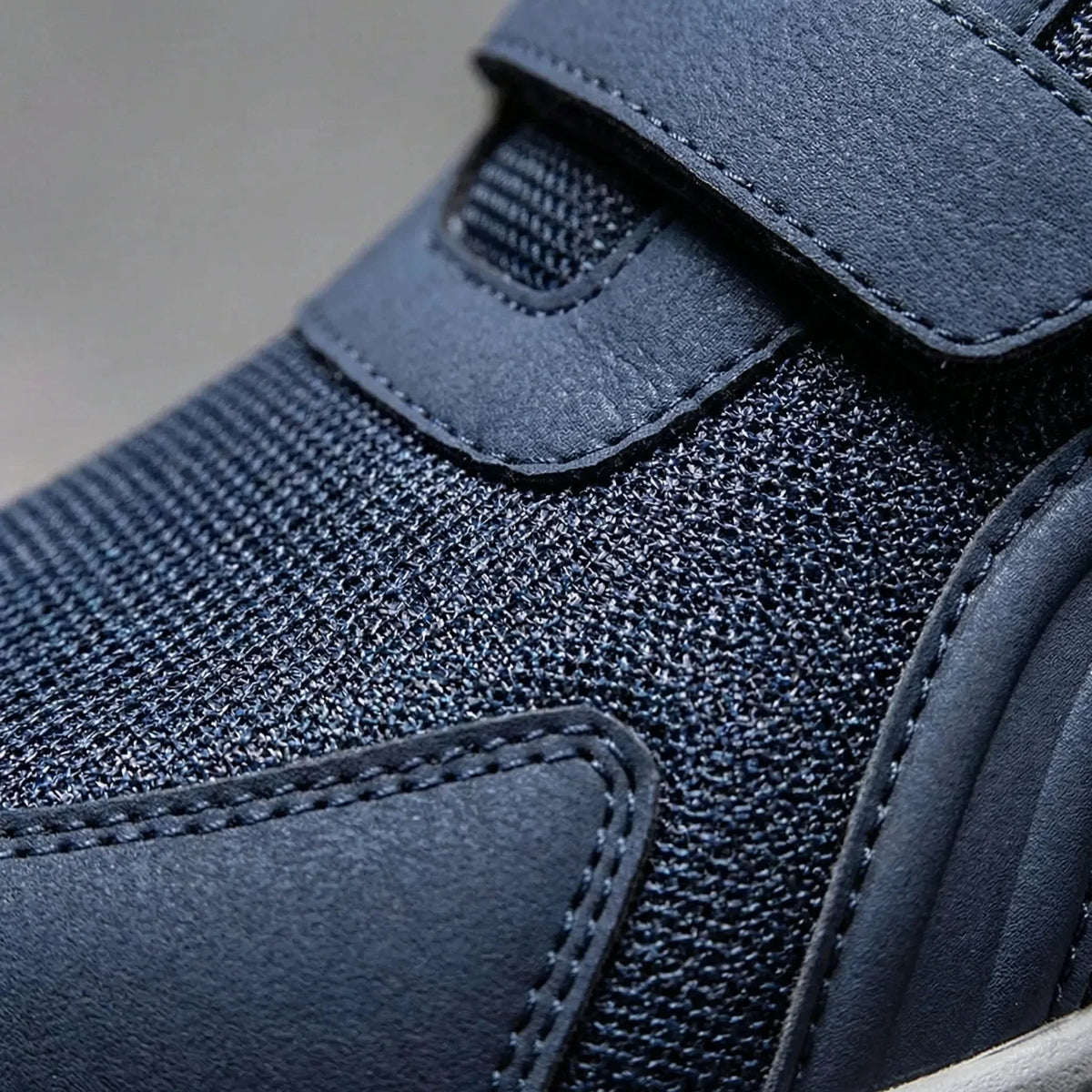 Nahaufnahme von Netzstoff, Nähten und Klettriemen am blauen Schuh 10