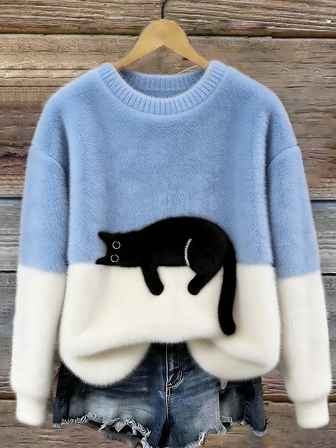 Flauschiger Pullover in Hellblau mit weißem Saum und aufgenähter schwarzer Katze, am Holzbügel vor Holzwand 1