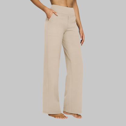 Seitenansicht der gerade geschnittenen Hose in hellem Beige an einer barfüßigen Frau, eine Hand in der Seitentasche. 7