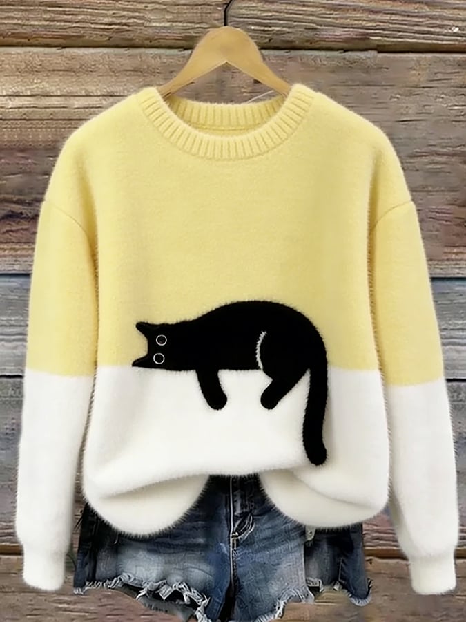 Flauschiger Pullover in Hellgelb mit weißem Saum und aufgenähter schwarzer Katze, am Holzbügel hängend 7
