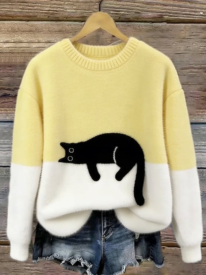 Gelb-weißer Flauschpullover mit schwarzer Katze auf Kleiderbügel vor Holzwand, darunter Jeansshorts 8