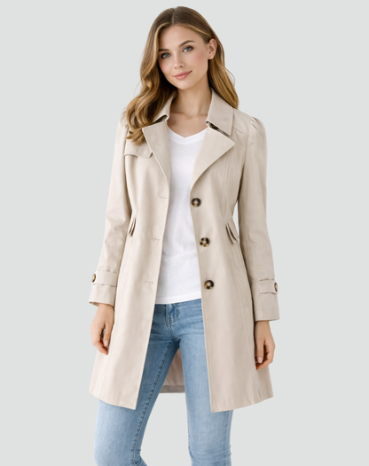 Frontansicht in hellem Creme-Beige: Model trägt den taillierten Trenchcoat mit dunklen Knöpfen über weißem Shirt und Jeans. 3