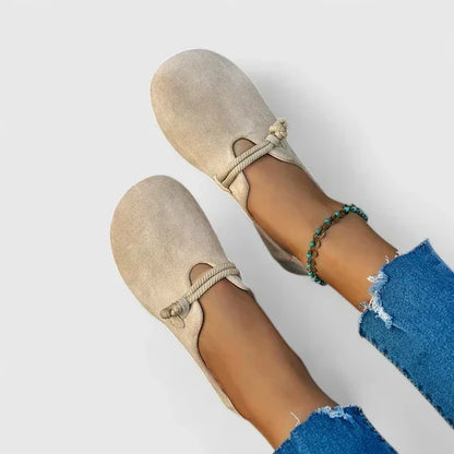 Beige Wildlederimitat-Loafer mit Zierkordel, von oben an den Füßen einer Frau in Jeans getragen 1