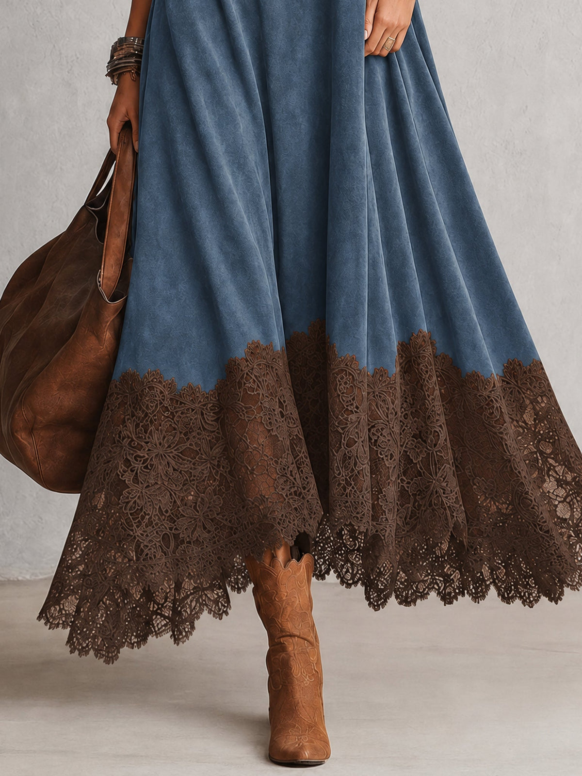 Nahaufnahme des braunen Spitzensaums am blauen Kleid, dazu Stiefel und Lederbeutel 12