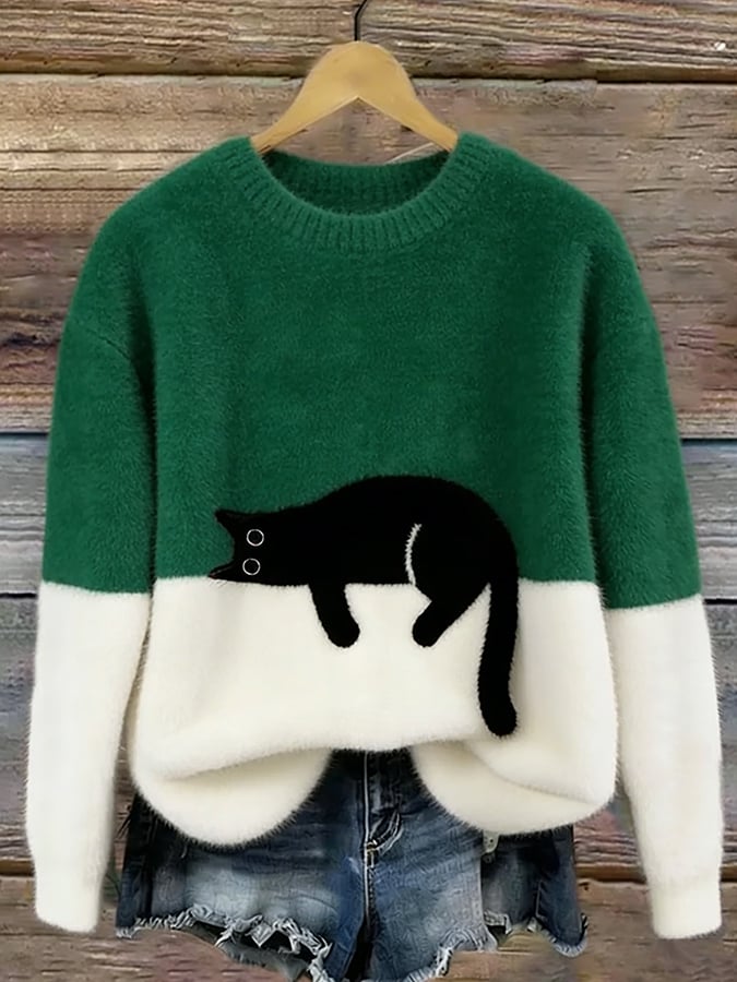 Flauschiger Pullover in Dunkelgrün mit weißem Saum und aufgenähter schwarzer Katze, am Holzbügel hängend 4