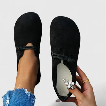 Schwarze Loafer in der Draufsicht, ein Schuh getragen, der andere zeigt die helle gepolsterte Innensohle 4