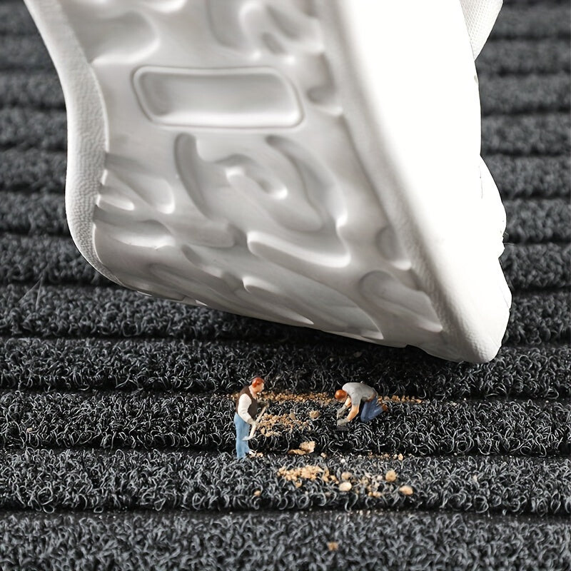 Detail der Fußmatte mit grauer Schlingenoberfläche und Streifenmuster.