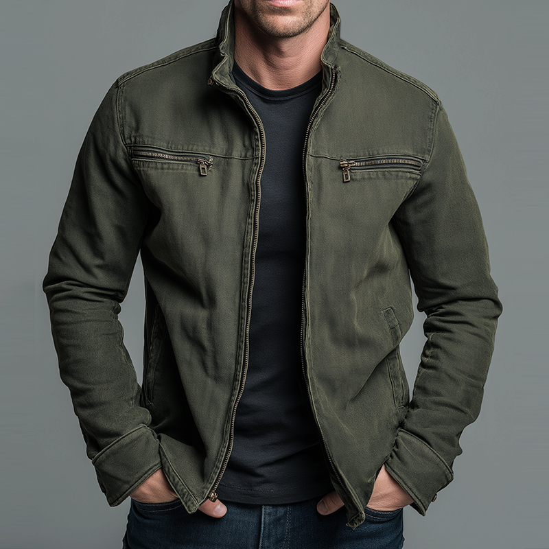 Olivgrüne Jacke mit Stehkragen und Brusttaschen mit Reißverschluss, getragen vor grauem Hintergrund, Vorderansicht 2