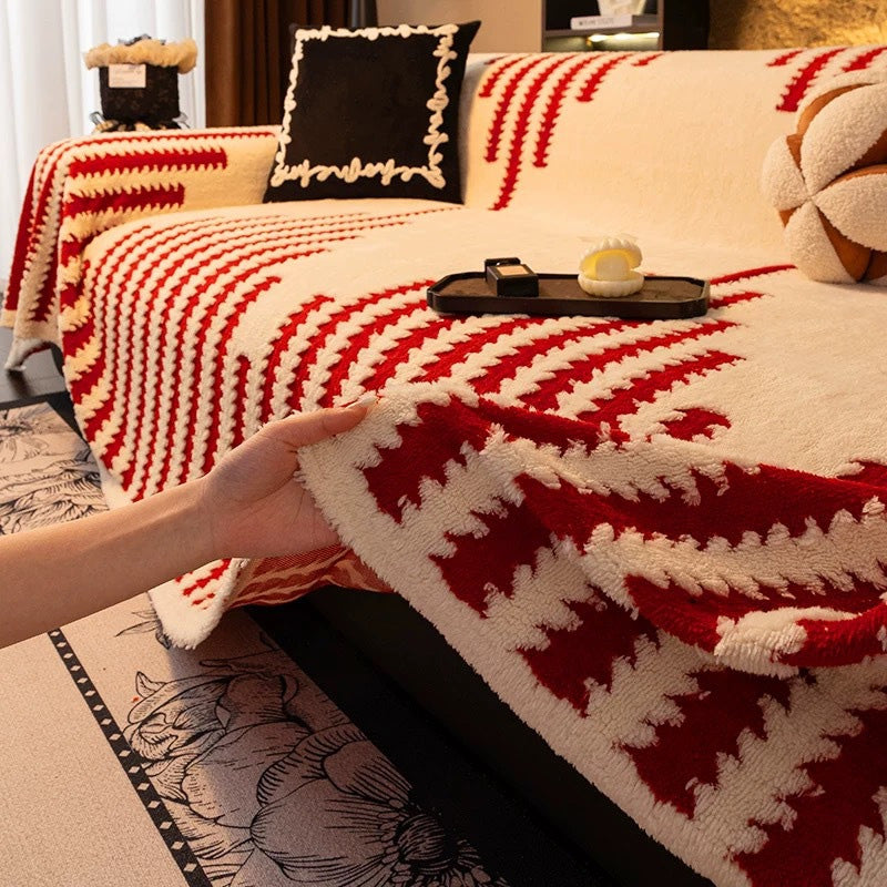 Roter Überwurf mit cremeweißem Zackenmuster auf dem Sofa, eine Hand hebt den Rand an 14