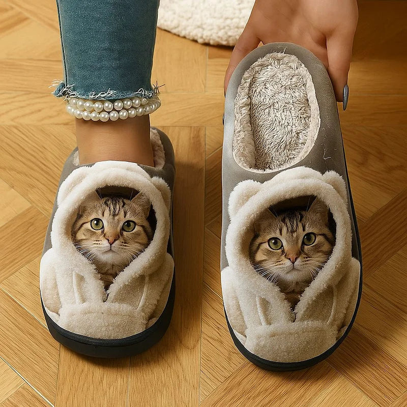 Ein Hausschuh am Fuß und der andere in der Hand mit sichtbarem flauschigem Innenfutter und Katzengesicht.