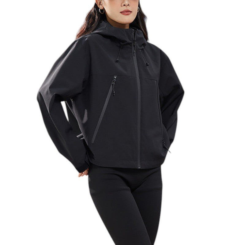 Nahaufnahme der schwarzen Jacke mit Kapuzenkordeln und Reißverschlusstaschen, Hände in die Taschen gesteckt 17