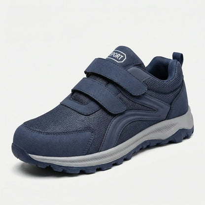 Einzelner blauer Schuh mit zwei Klettriemen und grauer Sohle, schräg von vorne auf hellem Grund 11