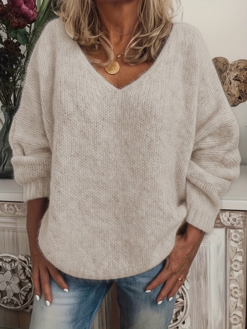 Strickpullover mit V-Ausschnitt in hellem Beige, weich wirkende Oberfläche, von einer Frau zu Jeans getragen. 4