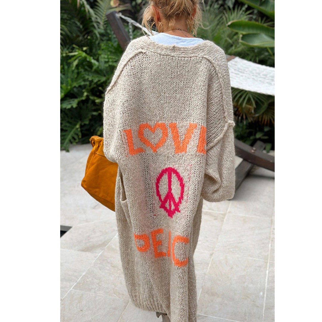 Frau im beigen Strickmantel mit "LOVE PEACE" Aufdruck, lässige Mode, Outdoor, Herbst.
