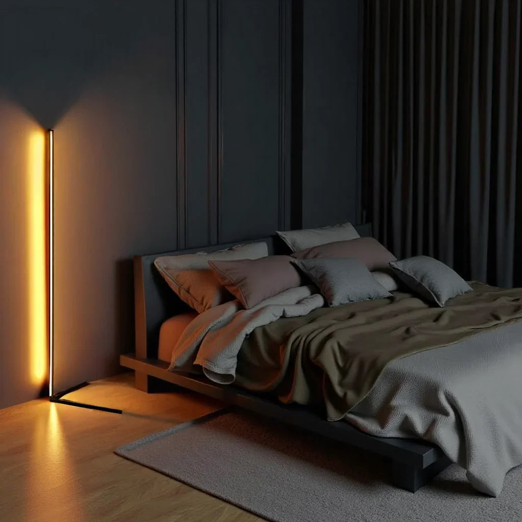 Stehlampe mit warmem Licht in einem dunklen Schlafzimmer mit Holzboden und grauer Bettwäsche 2