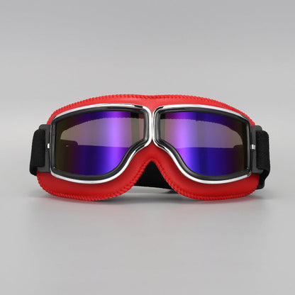 Brille mit rotem Lederrand und Chromrahmen, die Gläser schimmern verspiegelt in Violett und Blau. 12
