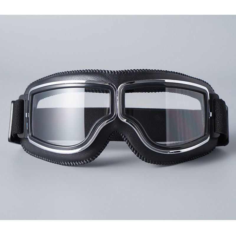 Schwarze Lederbrille mit Chromrahmen und klaren Gläsern von vorn, elastischer Riemen mit gepolsterten Seitenteilen. 16