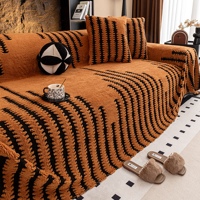 Orangebrauner Sofaüberwurf mit schwarzem Zackenmuster, passende Kissen, Tasse auf dem Sitz, Pantoffeln davor 12
