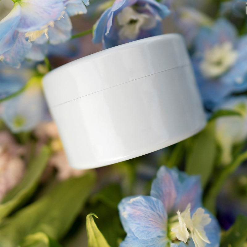 Weißer runder Blumenstecker-Vaseneinsatz mit Trennfuge inmitten von Blüten