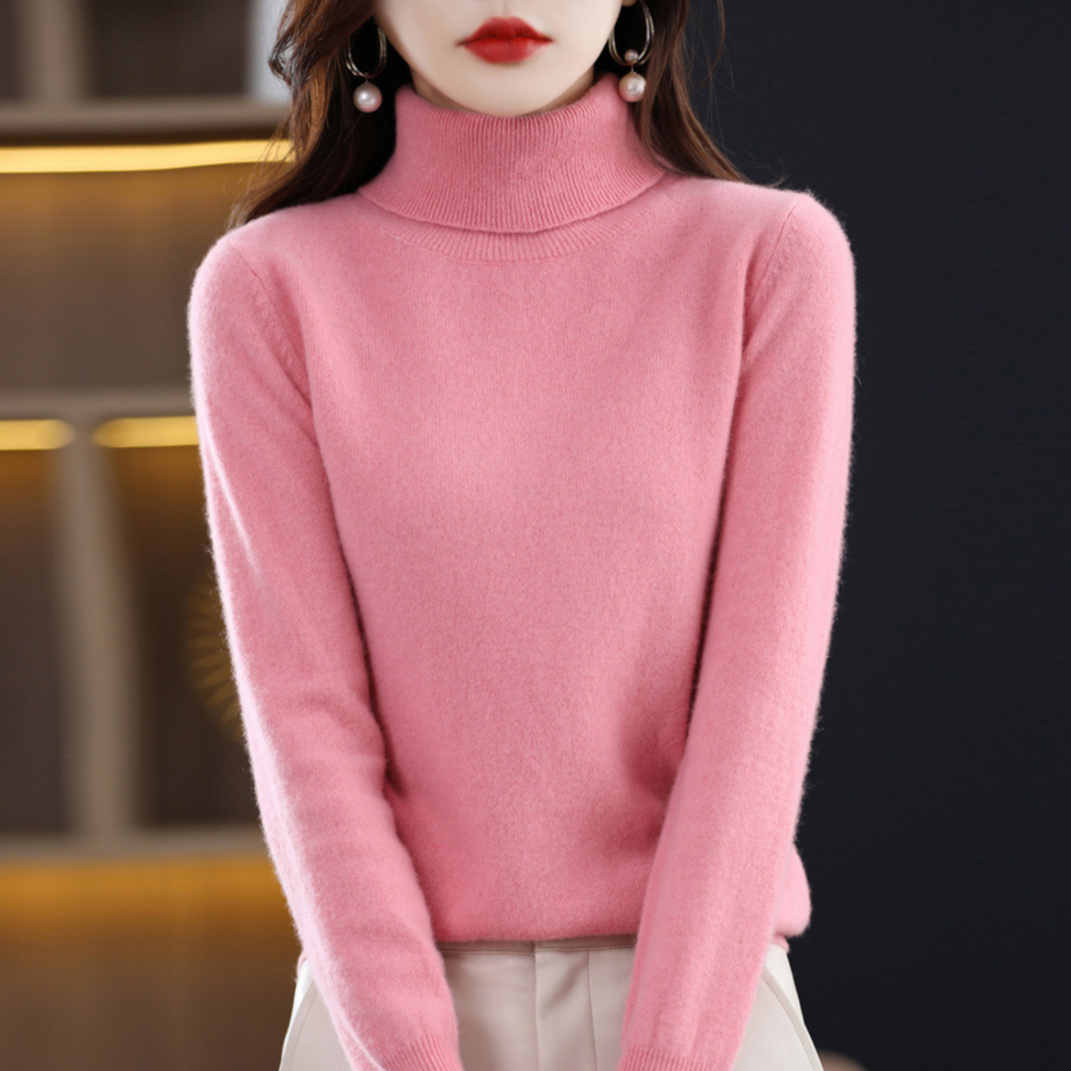 Rosafarbener Rollkragenpullover am Model mit heller Hose.
