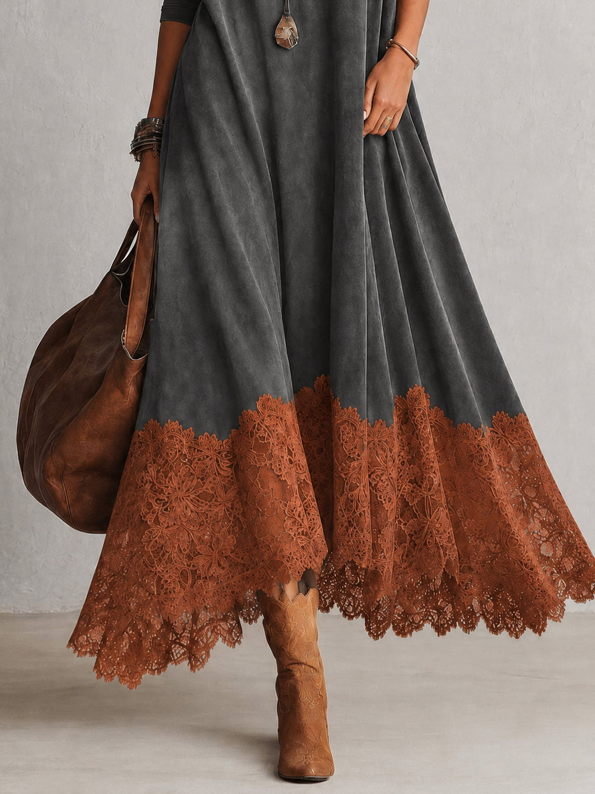 Nahaufnahme des rostorangen Spitzensaums am grauen Kleid, dazu Lederstiefel und Beutel 18