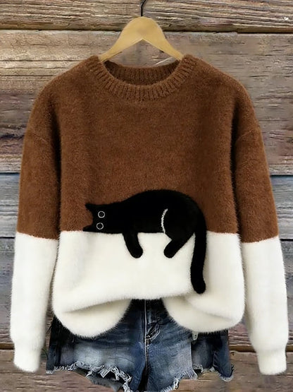Braun-weißer Flauschpullover mit schwarzer Katze auf Kleiderbügel vor Holzwand, darunter Jeansshorts 10