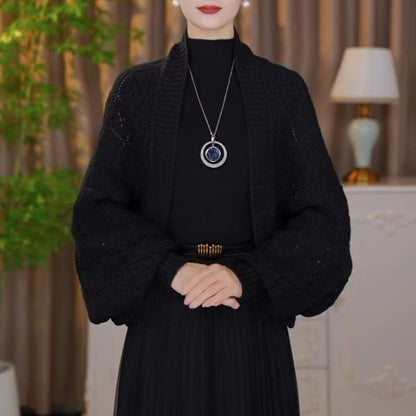 Schwarze Strickjacke mit durchbrochenem Muster und weiten Ärmeln, getragen über schwarzem Kleid 3