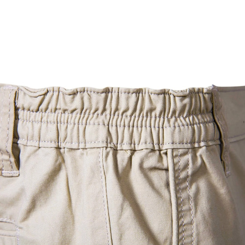 Detailaufnahme des gerafften Gummizugbunds in Beige mit Steppnähten und seitlichen Gürtelschlaufen. 4