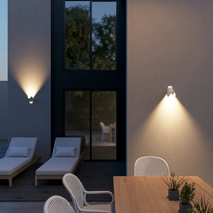 Weiße Wandleuchten im gedrehten Winkel an einer Terrassenwand am Abend.