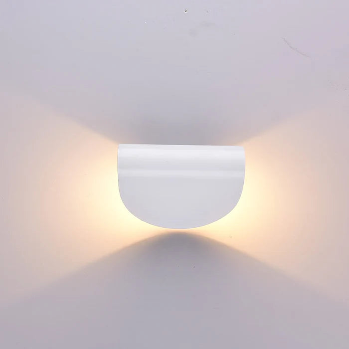 Frontansicht einer weißen halbrunden Wandleuchte mit warmem Licht, das nach oben und unten auf die Wand fällt.