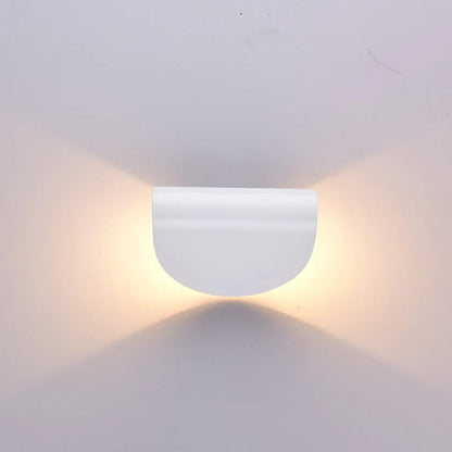 Frontansicht einer weißen halbrunden Wandleuchte mit warmem Licht, das nach oben und unten auf die Wand fällt.