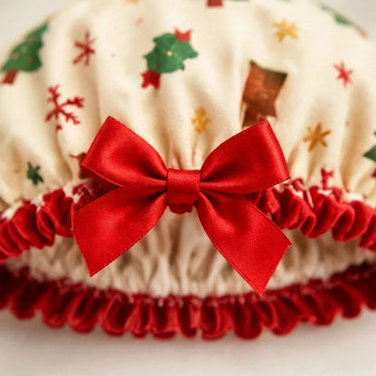 Nahaufnahme der cremefarbenen Duschhaube mit Weihnachtsmotiven, roter Satinschleife und gerüschtem roten Rand 3