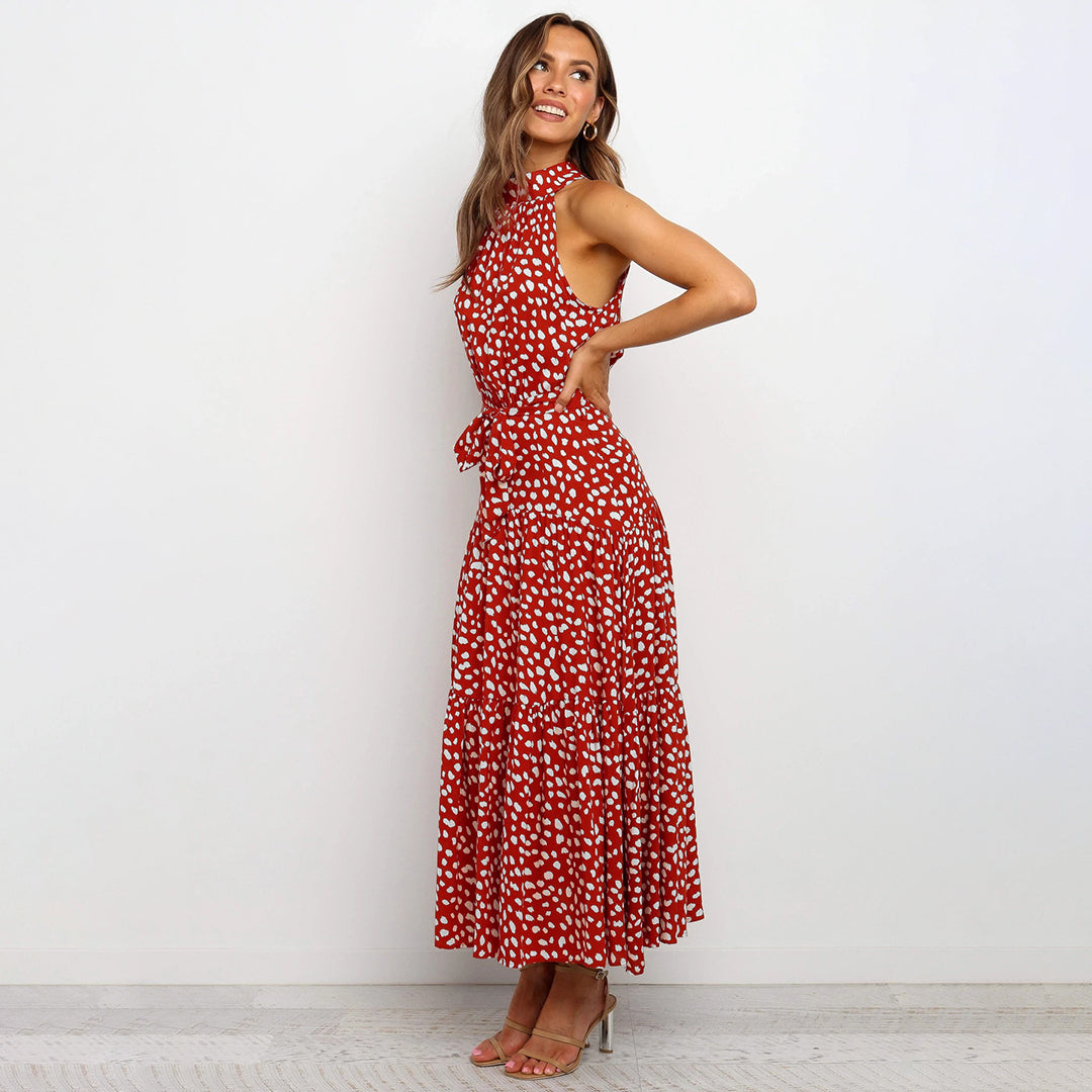Frau in rotem, gepunktetem Maxikleid, ärmellos, mit Schleife, elegant, modisch.
