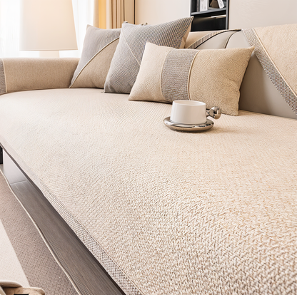 Einfarbiger Sofabezug in hellem Creme-Beige mit weicher, flauschiger Oberfläche, dazu beige und graue Kissen. 9