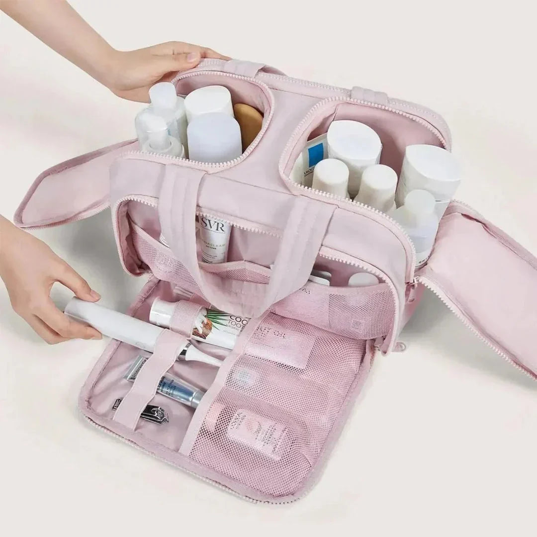 Geöffneter rosa Kulturbeutel mit Pflegeflaschen, elektrischer Zahnbürste und Netzfächern, detail