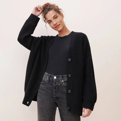 Frau trägt schwarzen Strick-Cardigan mit Knöpfen, lässiger Stil, modische Damenbekleidung.