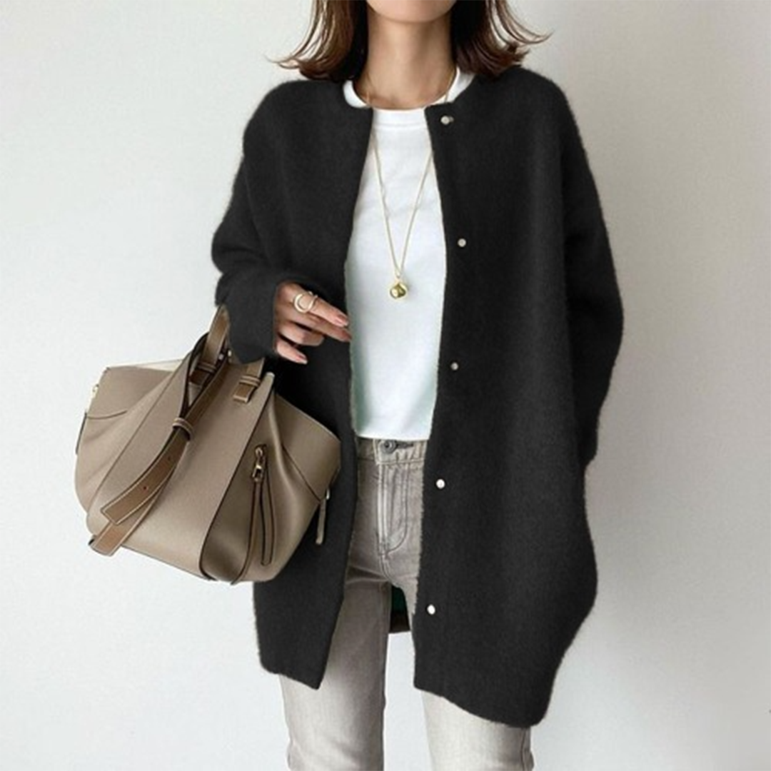 Flauschiger Cardigan in Schwarz mit Druckknöpfen, kombiniert mit weißem Shirt, hellgrauer Jeans und Handtasche 4
