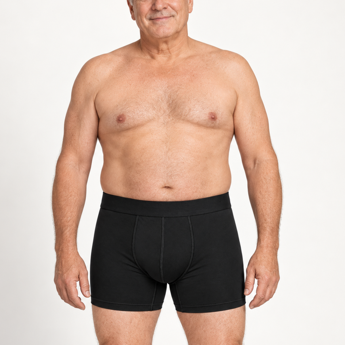 Älterer Mann zeigt schwarze Boxerbriefs in der Frontansicht mit breitem Bund und Ziernähten am Eingriff.