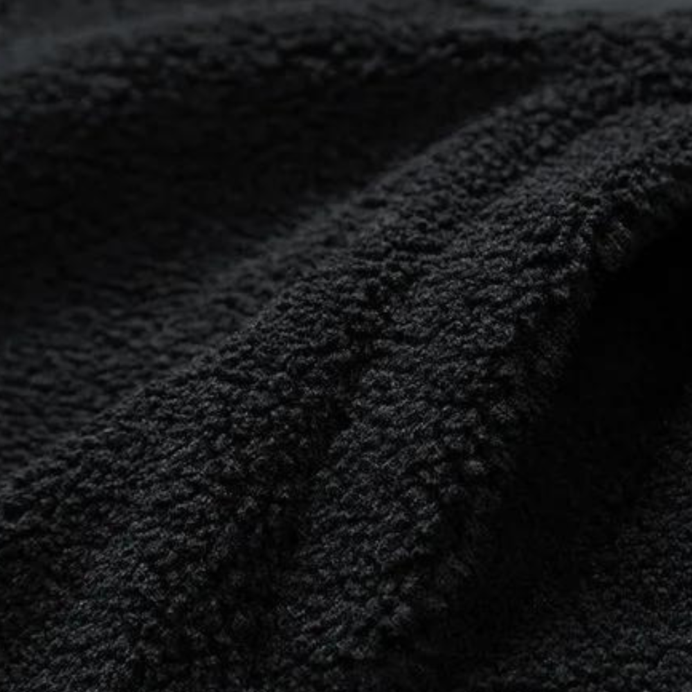 Schwarzer Fleece-Stoff, weiche Textur, Nahaufnahme, ideal für warme Kleidung und Decken.