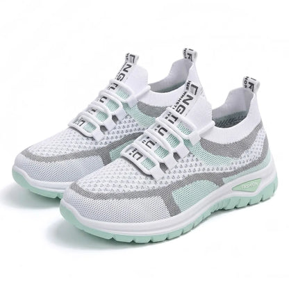 Paar weiß-mintgrüne Mesh-Sneaker mit Gummischnürung schräg von vorn auf weißem Hintergrund.