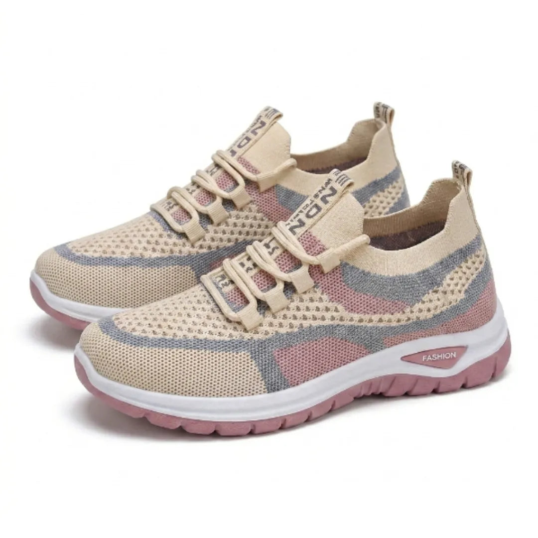 Paar beige Mesh-Sneaker mit rosa und grauen Akzenten und rosa Sohle in Schrägansicht auf weißem Hintergrund 34