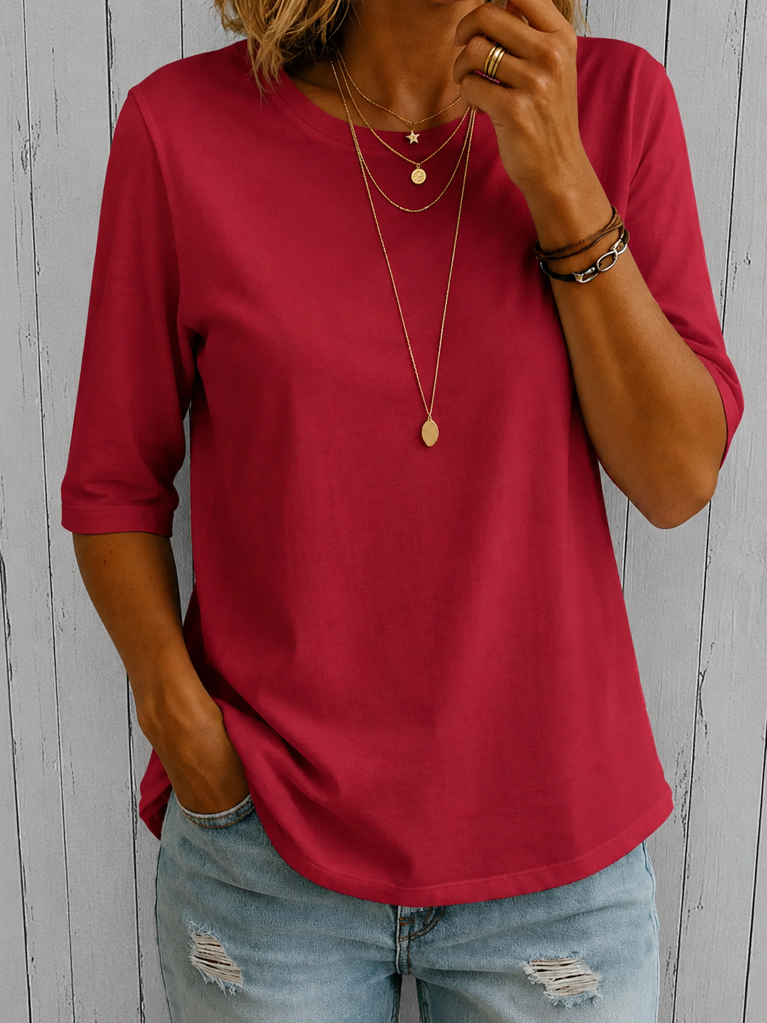 Rotes Halbarm-Shirt mit Rundhals, Frontansicht vor Holzwand.