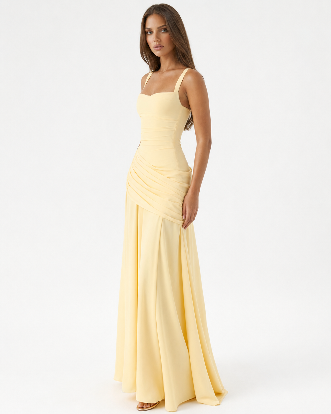 Das gelbe Maxikleid in seitlicher Dreiviertelansicht am Model, mit gerafftem Drapé an der Hüfte und weit fließendem Rock. 2