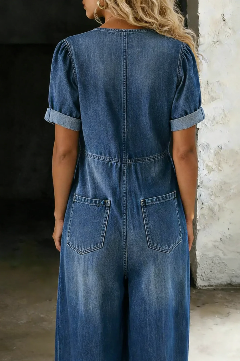 Rückansicht des blauen Jeansoveralls mit aufgesetzten Gesäßtaschen, Taillennaht und umgeschlagenen kurzen Ärmeln 5