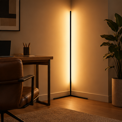 Schwarze LED-Eck-Stehlampe im Arbeitszimmer neben Schreibtisch, Ledersessel und großer Zimmerpflanze, die Wand warm beleuchtend. 3