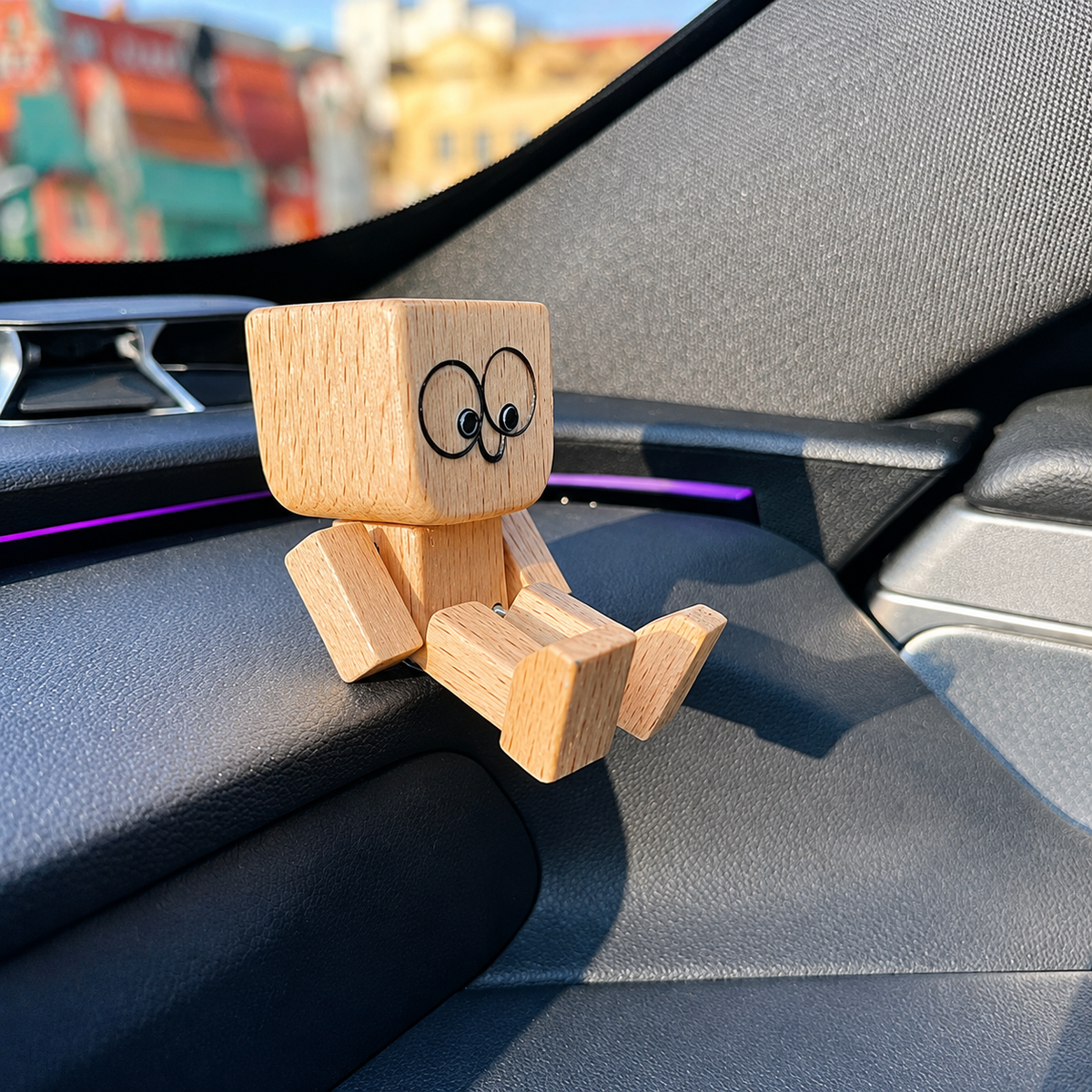Holzfigur aus Holz, seitlich von schräg vorn auf dem Armaturenbrett eines Autos gesehen.
