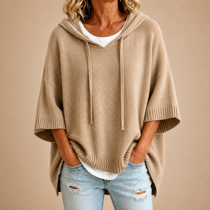 Beiger Strickponcho mit Kapuze und Kordelzug am V-Ausschnitt, Vorderansicht.