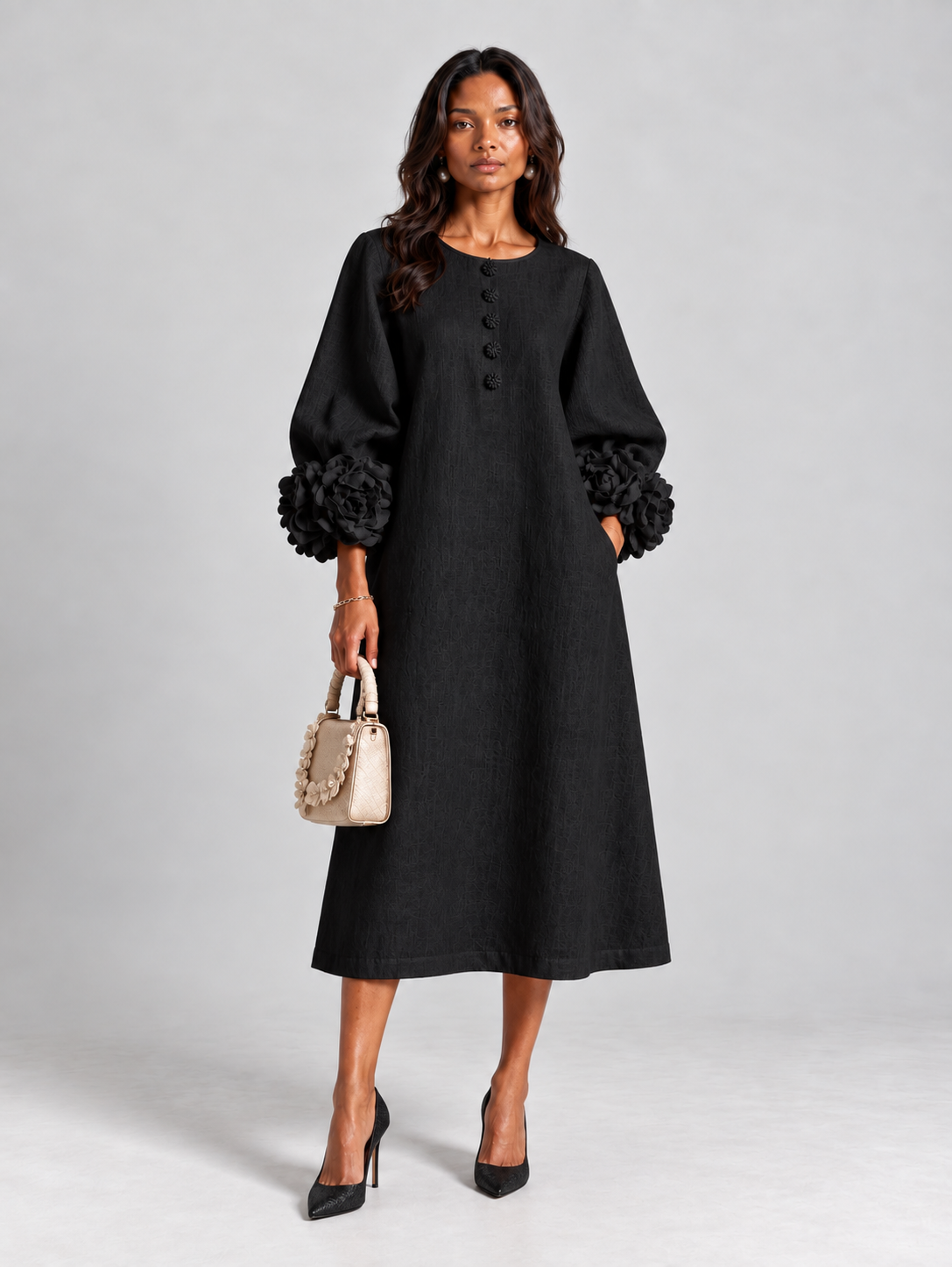 Schwarzes Kleid aus Leinen mit Blütenknöpfen und Stoffblüten, Frontansicht am Model